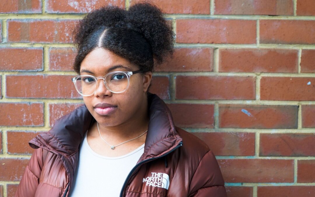 Young black woman against brick wall